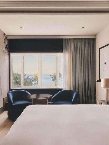 Stilvolles Hotelzimmer mit Sitzbereich und Blick auf das Meer