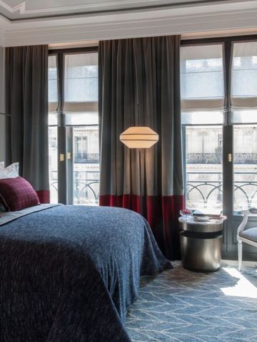 Elegantes Hotelzimmer mit großzügiger Fensterfront und stilvollem Interieur.