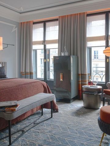 Gemütliches Zimmer mit moderner Einrichtung und großem Fenster im Nolinski Paris.