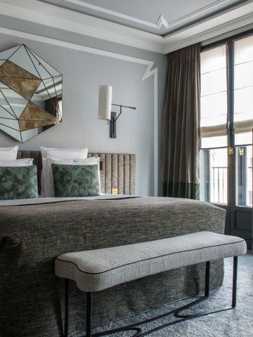 Geschmackvoll eingerichtetes Hotelzimmer mit großer Fensterfront und eleganter Dekoration