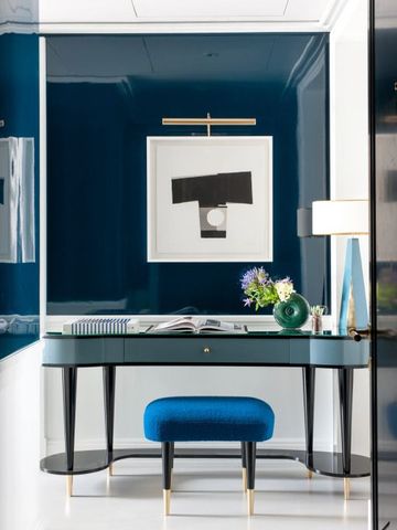 Schreibtischbereich mit künstlerischem Bild und blauen Akzenten im Hotelzimmer