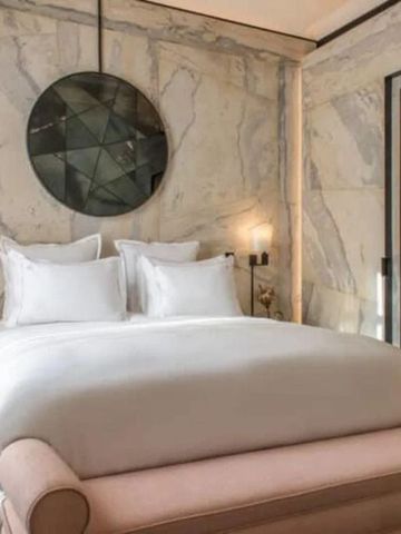 Gepflegtes Schlafzimmer mit modernem Dekor und marmorierten Wänden.