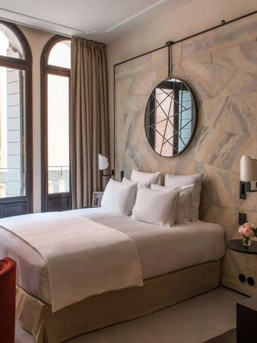 Komfortables Hotelzimmer mit großem Fenster und eleganter Einrichtung im Nolinski Venezia.