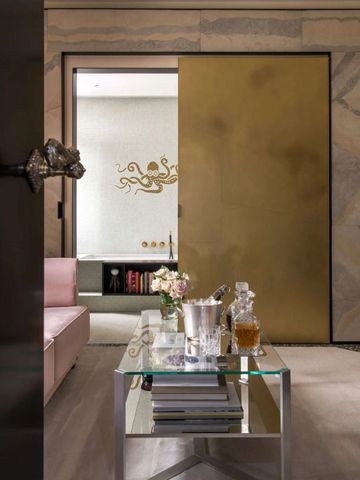 Moderne Wohnzimmereinrichtung mit Glastisch und goldener Wanddekoration