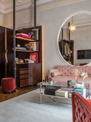 Komfortabler Wohnbereich mit rosa Sofa und dekorativem Spiegel