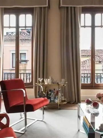 Eleganter Wohnbereich einer Suite mit roten Sesseln und großen Fenstern im Nolinski Venezia