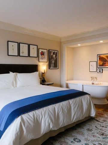 Komfortables Schlafzimmer mit freistehender Badewanne und moderner Dekoration