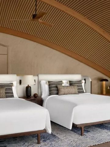 Zimmer mit zwei Doppelbetten und stilvoller Einrichtung in natürlichem Design