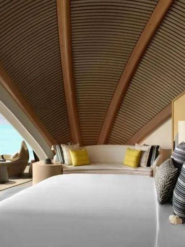 Schlafzimmer mit Meerblick, großer Fensterfront und komfortabler Sitzgelegenheit