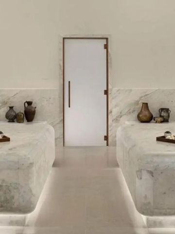 Spa-Behandlungsraum mit Marmortischen und edlen Dekorationen, minimalistisch gestaltet