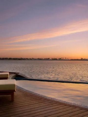 Infinity Pool mit Blick auf ruhigen Ozean bei Sonnenuntergang