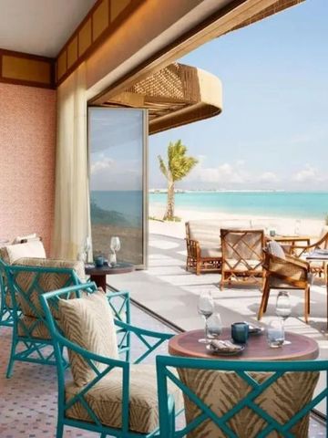 Gemütliche Outdoor-Sitzmöbel auf einer Terrasse mit Strandblick