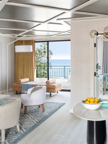 Helles Zimmer mit Meeresblick und modernen Sitzmöbeln vor großen Fenstern