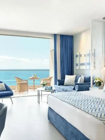 Helles Hotelzimmer mit Meerblick und eleganter Möblierung im Ikos Oceania Hotel
