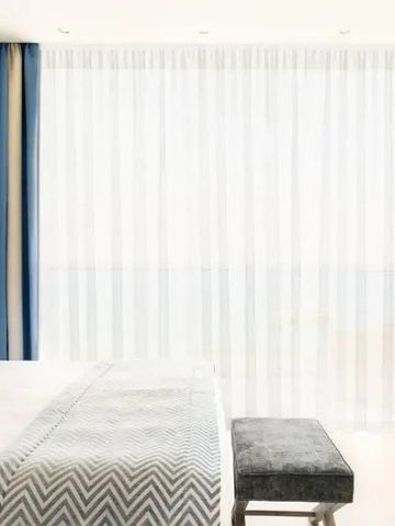 Hotelzimmer mit Vorhängen und stilvoller Einrichtung im Ikos Oceania Hotel