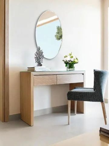 Moderner Schminktisch mit Spiegel neben einem großen Fenster.