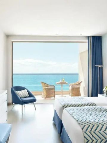 Modernes Hotelzimmer mit Blick auf das Meer und eleganten blauen Akzenten