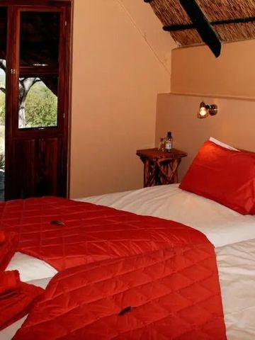 Schlafzimmer mit zwei Einzelbetten und Blick auf die namibische Landschaft