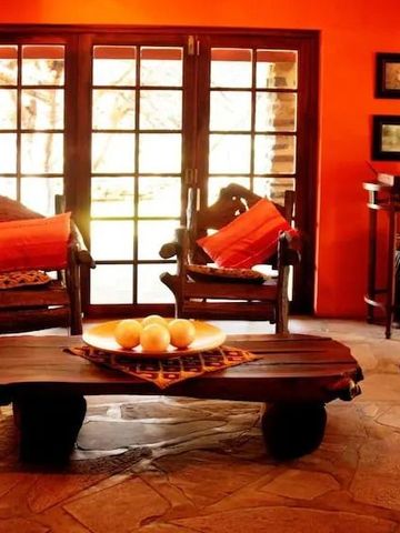 Eleganter Wohnbereich mit großen Fenstern und orangen Wänden