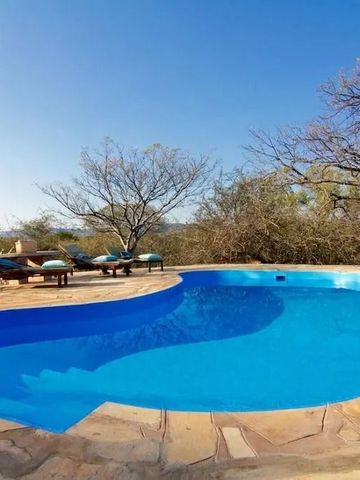 Kristallklarer Pool mit Liegestühlen unter blauem Himmel im Freien