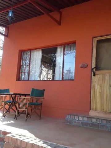 Gemütliche Veranda mit Sitzgelegenheiten vor einem orangefarbenen Haus