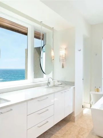 Helles Badezimmer mit Badewanne und herrlichem Meerblick.