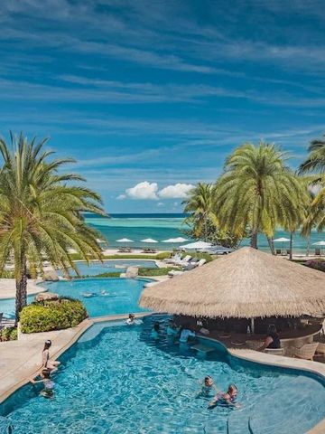 Tropischer Poolbereich mit Palmen und Blick auf das Meer