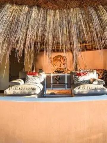 Gemütliche Außenlounge mit Strohdach und Kissen dekoriert