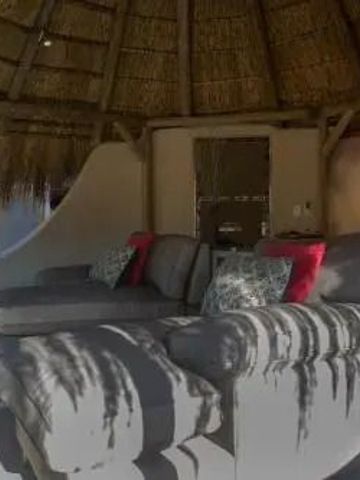 Gemütliche Sitzecke unter einem strohgedeckten Dach im Okonjima Luxury Bush Camp.