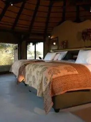 Luxuriöses Schlafzimmer mit traditionellen afrikanischen Dekorationen und Aussicht.