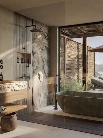 Luxuriöses Badezimmer mit freistehender Wanne und Natursteinwänden