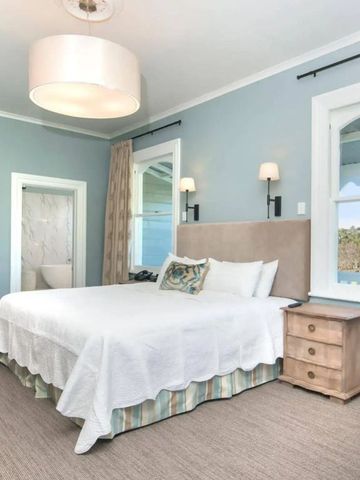 Lichtdurchflutetes Gästezimmer mit hellem Dekor und Blick ins Grüne