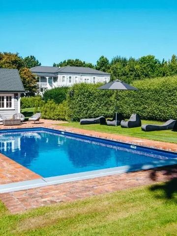 Außenpool mit Liegen in einem Gartenbereich bei sonnigem Wetter