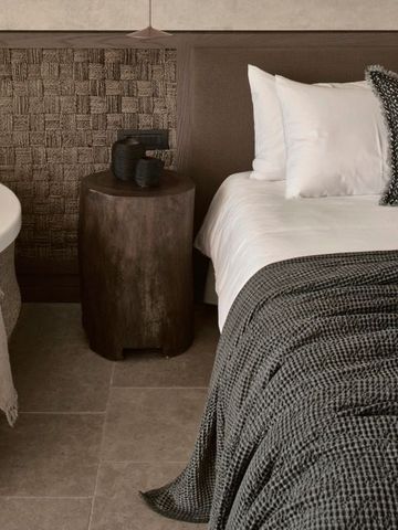 Gemütliches Schlafzimmerinterieur mit Badewanne und Holzakzenten