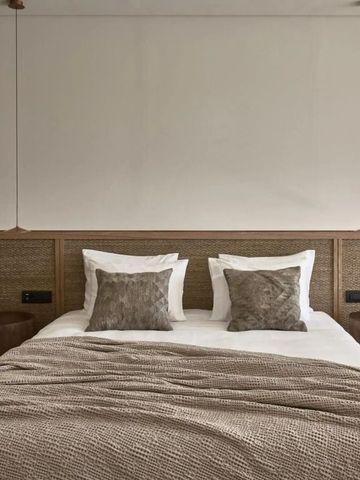 Komfortables Doppelbett mit neutralen Farben und stilvollen Akzenten