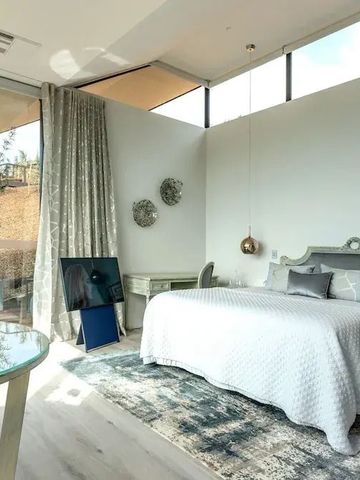 Zimmer mit schicker Einrichtung und großen Fenstern für viel Tageslicht