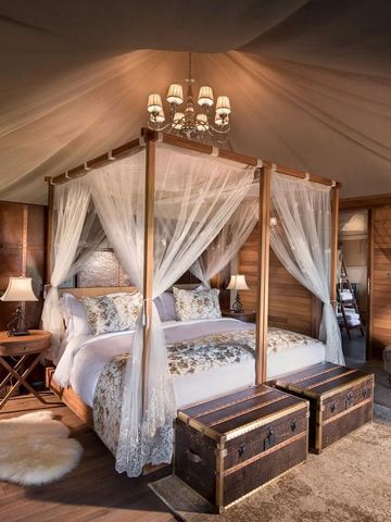 Großes Kingsize-Bett mit Baldachin in einer luxuriösen Safari-Zeltsuite