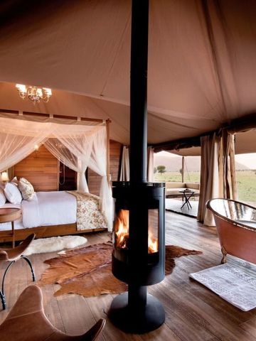 Safari-Zelt mit Kamin und freistehender Badewanne mit Ausblick in die Natur