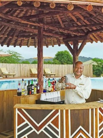 Außenbar mit Holzdesign und Barkeeper beim Mixen von Getränken