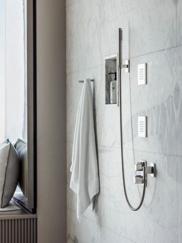 Luxuriöse Regendusche in einem eleganten Marmorbad mit Blick auf Dubai