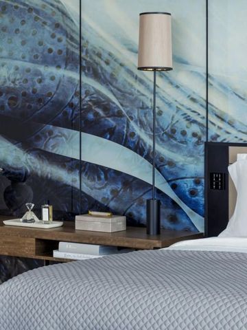 Modernes Hotelzimmer mit stilvoller blauer Wandgestaltung und komfortablem Bett