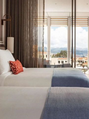 Doppelzimmer mit moderner Einrichtung und großem Fenster.