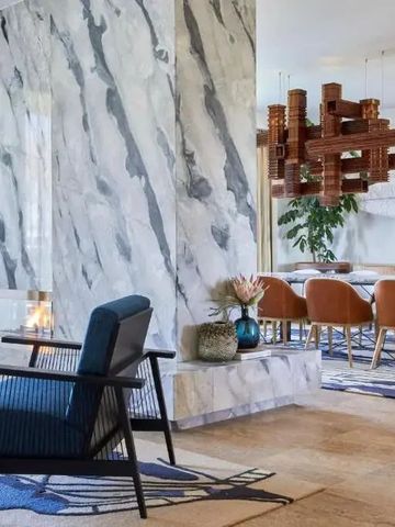 Eleganter Wohnbereich mit Marmor-Kamin und Designerstühlen