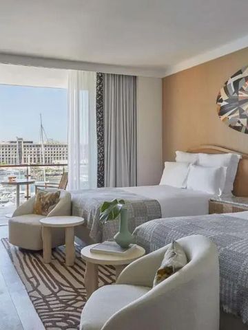 Geräumiges Hotelzimmer mit zwei Betten und Balkonblick auf das Wasser