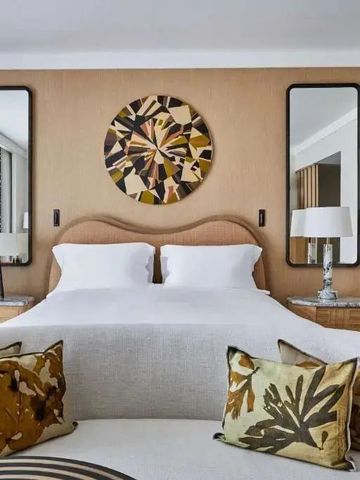 Elegantes Schlafzimmer mit großen Spiegeln und kunstvoller Wanddekoration