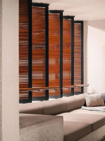 Gemütliche Lounge mit Holzjalousien und Polstermöbeln