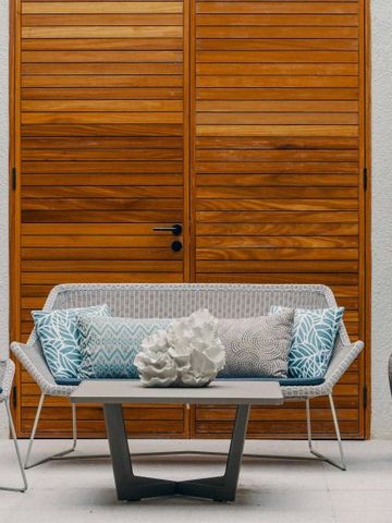 Außenterrasse mit Holzmöbeln und stilvoller Dekoration