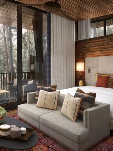 Elegantes Hotelzimmer mit großem Bett und Aussicht auf den Wald.