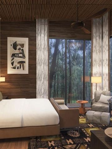 Modernes Schlafzimmer mit großen Fenstern und Waldblick.