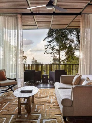 Wohnbereich mit großer Fensterfront und Blick auf die Natur